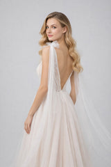 Robe de mariage Dressie Dress à décolleté plongeant en tulle avec broderies graphiques et longs pans aux épaules.