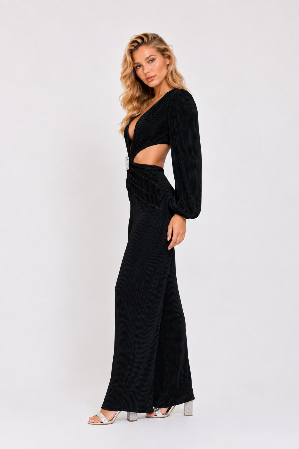 Combinaison femme noire Dressie Dress plissée avec décolleté profond, découpes à la taille et boucle fleur pour un look chic.