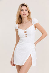 Robe en dentelle florale blanche Dressie Dress, style romantique avec taille marquée et jupe wrap fendue.