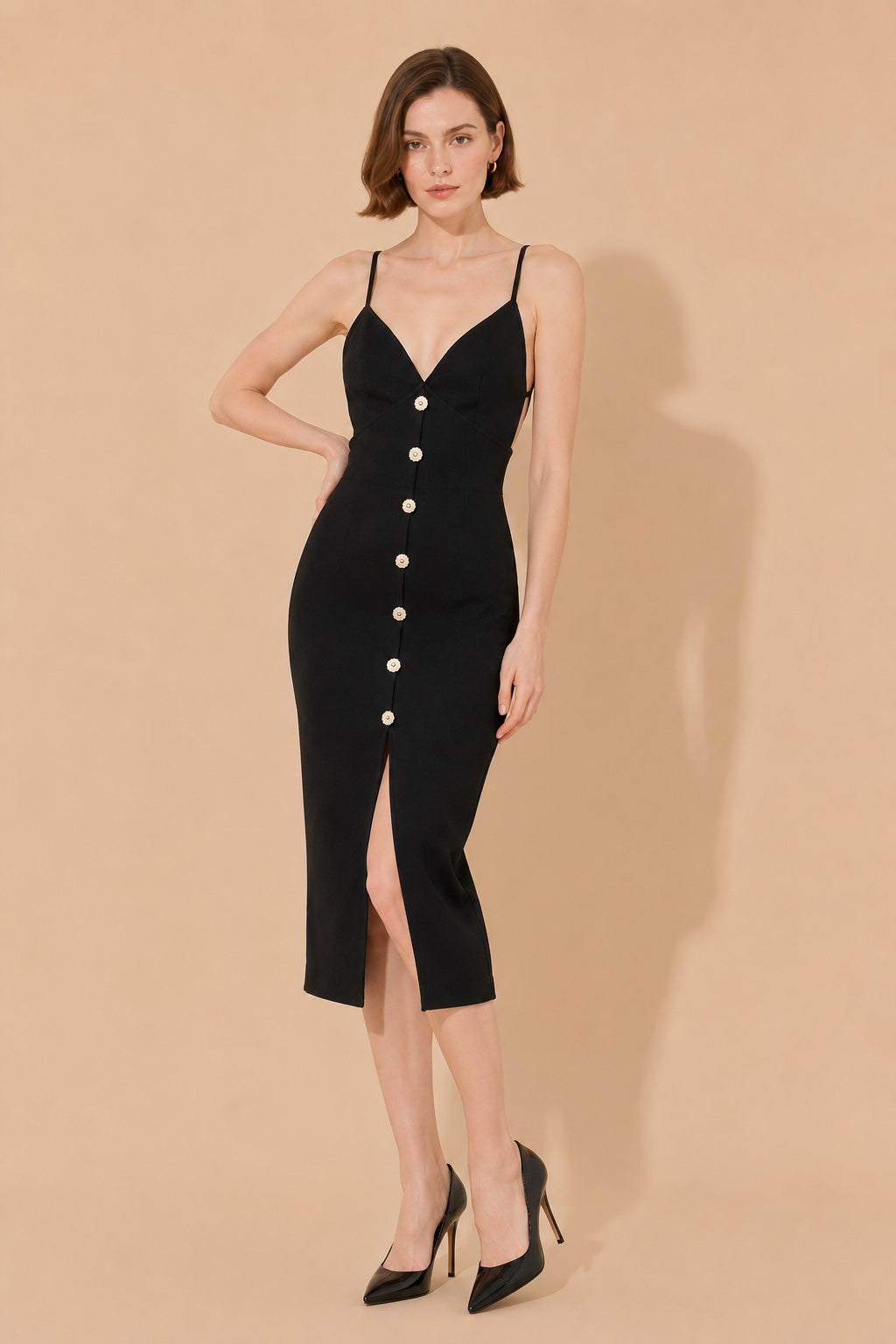 Robe bandage mi-longue noire Dressie Dress avec bretelles fines, décolleté en V, dos nu, fente avant et détails bijoux.
