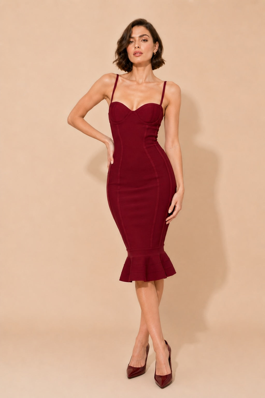 Robe bandage noire Dressie Dress à décolleté cœur, fines bretelles et ourlet sirène volanté, longueur mi-longue élégante et sexy.