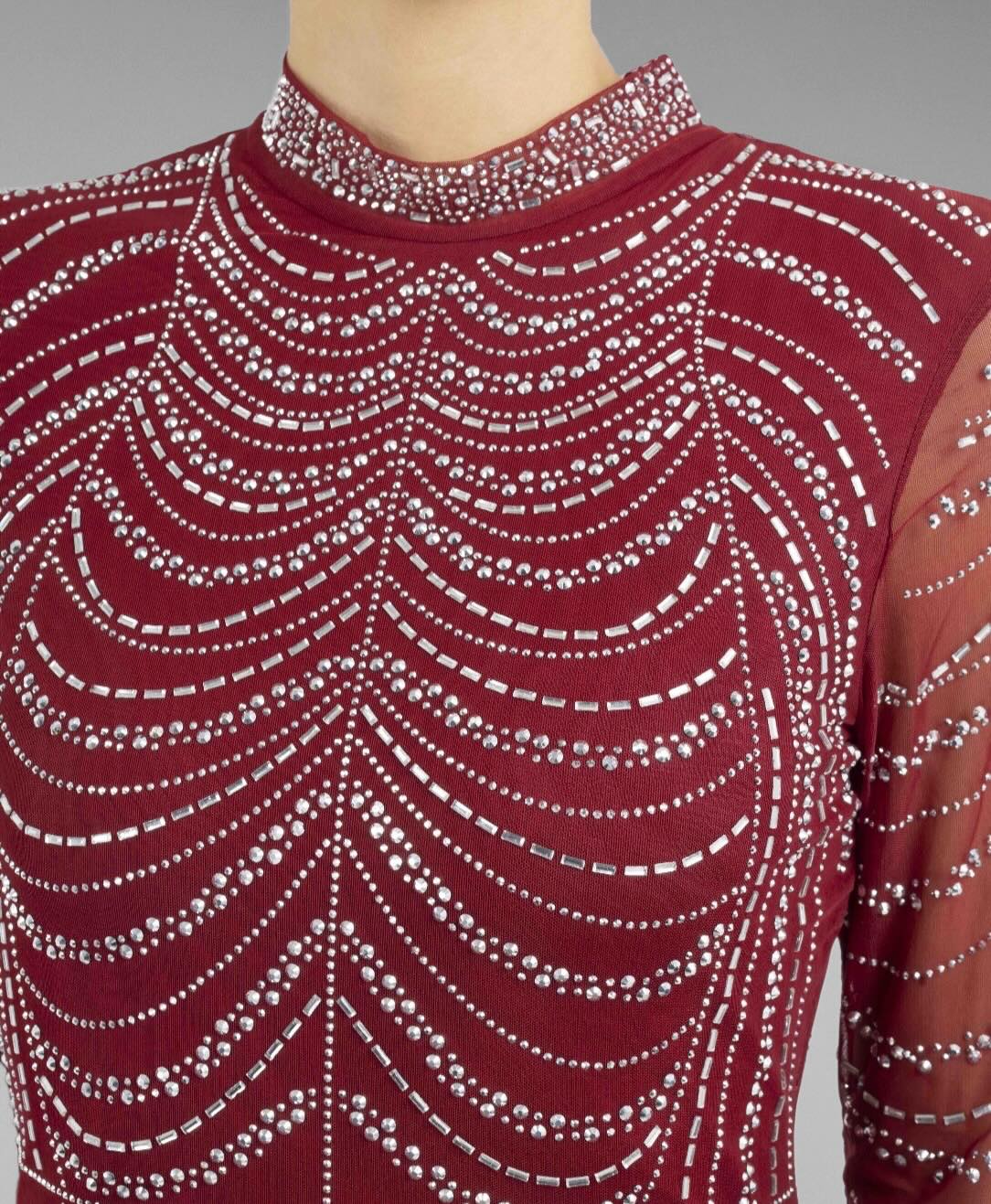 Robe de soirée longue rouge moulante avec col montant, manches longues en tulle strass et motif chaînes, brillante et élégante.