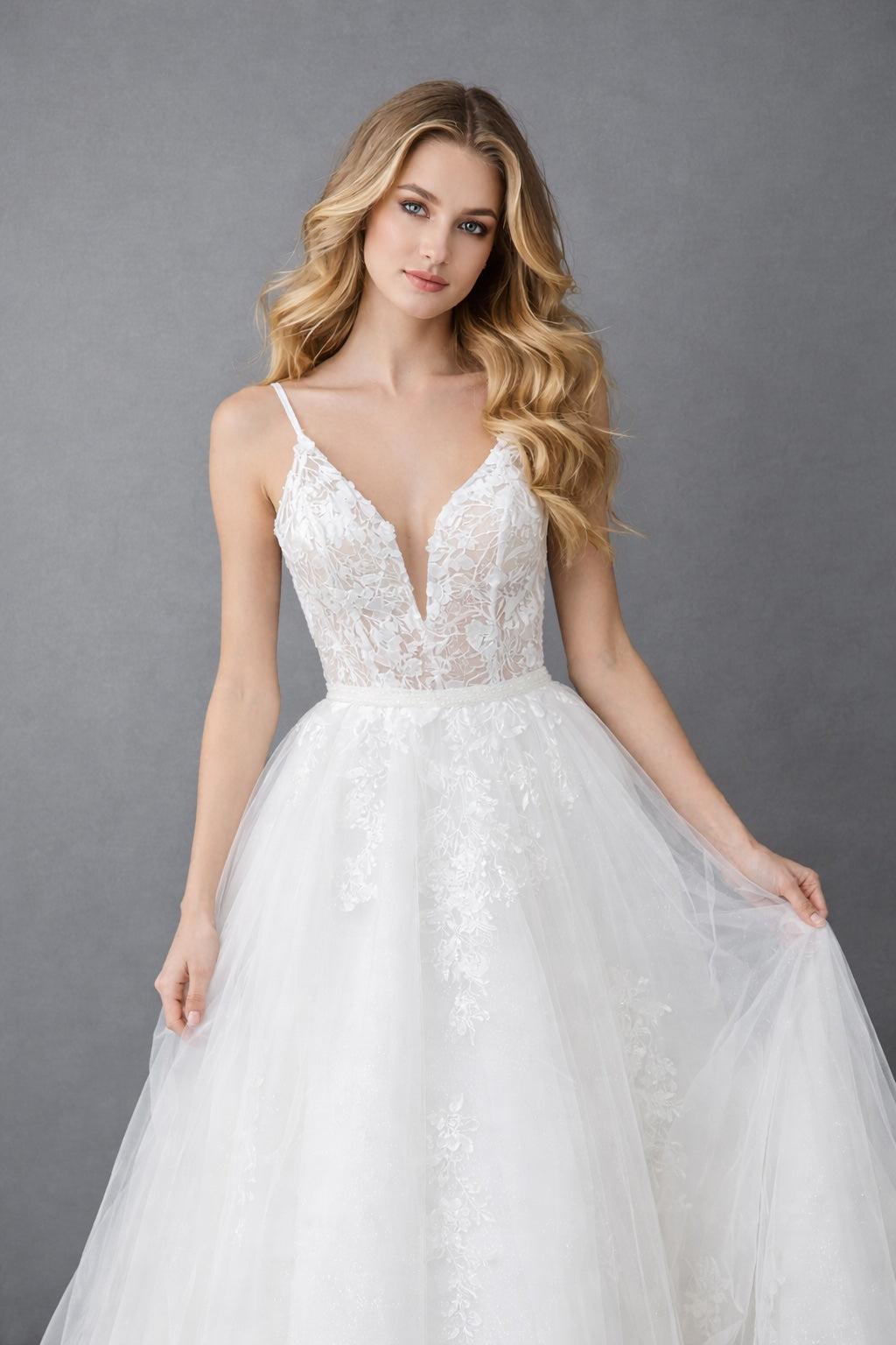 Robe de mariée Dressie Dress à fines bretelles, décolleté plongeant, dentelle florale et jupe aérienne avec traîne élégante.