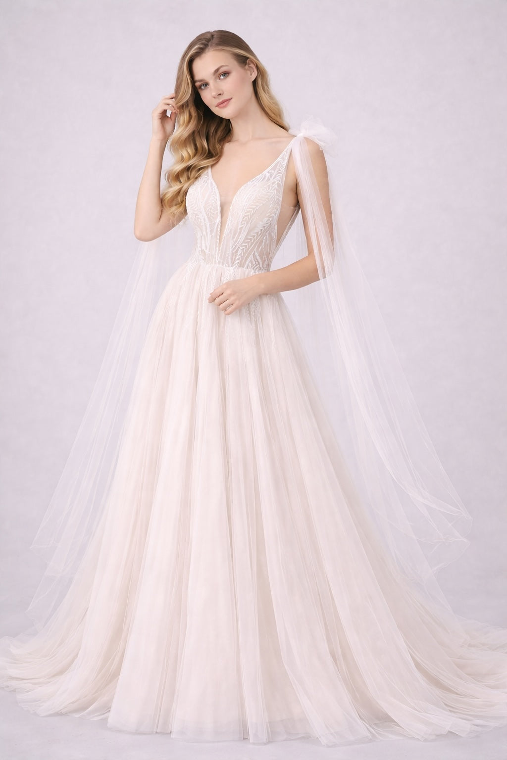 Robe de mariage Dressie Dress à décolleté plongeant, tulle brodé graphique, pans drapés aux épaules, silhouette aérienne élégante.