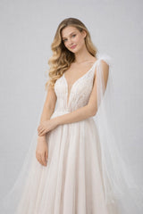 Robe de mariage Dressie pour mariée, décolleté plongeant, tulle illusion brodé, longs pans drapés, silhouette aérienne.
