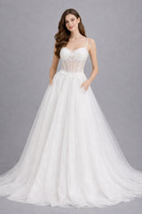 Robe de mariée Dressie avec fines bretelles, corsage transparent brodé de fleurs, grande jupe à traîne, silhouette élégante.