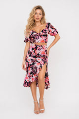 Robe midi femme imprimée fleurie rose avec découpe à la taille, fente, ourlet volanté et manches courtes bouffantes, style romantique.